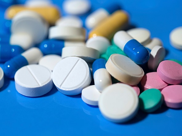pile of different coloured tablets for various medications